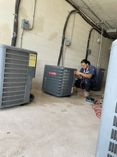 A-OK Services technician diagnosing AC system problems in San Antonio home